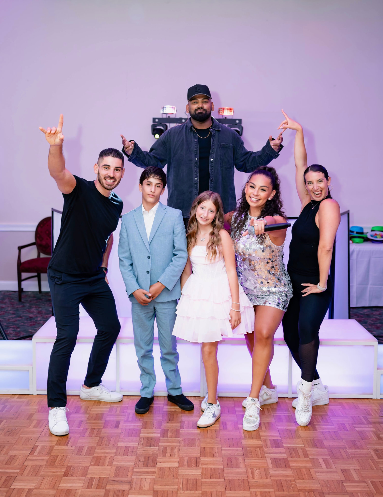 ILP performers and dancers posing with young guests on a lit event floor